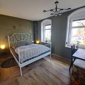a bedroom with a white bed and two windows at Goldener Blick in Stollberg +42 photos