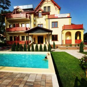 a person in a pool in front of a house at Apartman Maxim in Palić