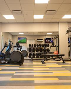 a gym with treadmills and machines in a room at Ibis Monterrey Aeropuerto in Monterrey
