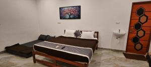 a bedroom with two beds and a sink in it at La Nature Retreat in Puducherry Airpoert