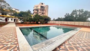 a swimming pool in front of a building at La Nature Retreat in Puducherry Airpoert