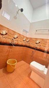 a bathroom with a shower and a toilet and a bucket at La Nature Retreat in Puducherry Airpoert