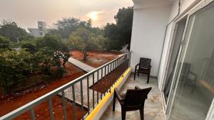 a balcony with two chairs and a view of a yard at La Nature Retreat in Puducherry Airpoert