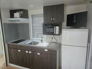 a small kitchen with a sink and a microwave at Camping Arenas in Bareyo