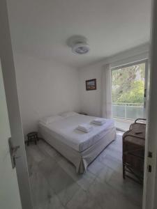 a bedroom with a bed and a large window at Varkiza Pines Apartment in Varkiza