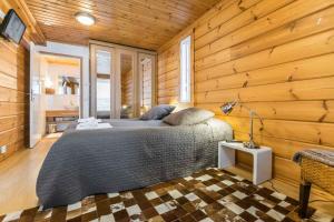 a bedroom with a bed in a wooden wall at Päijänteen Helmi 1 in Jämsä