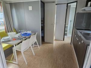 a small kitchen with a table and chairs in a room at Camping Arenas in Bareyo +7 photos