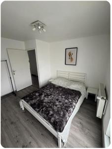 a bedroom with a bed in a white room at Chez moi in Mont-Saint-Martin