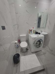 a white bathroom with a toilet and a sink at Varkiza Pines Apartment in Varkiza +16 photos