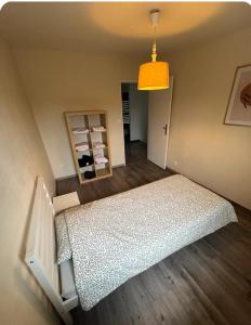 a bedroom with a bed and a yellow light at Chez moi in Mont-Saint-Martin +2 photos