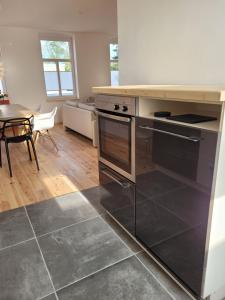 a kitchen with stainless steel appliances and a table at Haus Sonnen mit 3 Apartments in Nettetal