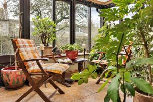 a patio with a chair and a table with plants at Finest Retreats - Vine Barn in Bellerby