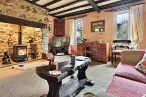 a living room with a couch and a stone fireplace at Finest Retreats - Vine Barn in Bellerby
