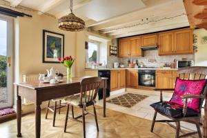 a kitchen with a wooden table and chairs at Finest Retreats - Vine Barn in Bellerby