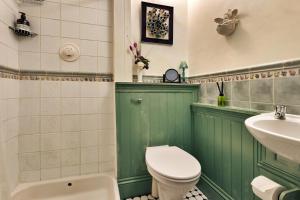 a green bathroom with a toilet and a sink at Finest Retreats - Vine Barn in Bellerby +12 photos