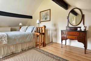 a bedroom with a bed and a dresser and a mirror at Finest Retreats - Vine Barn in Bellerby