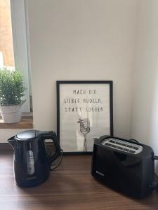 a toaster and a toaster on a table with a picture at Auszeit in Bad Sobernheim