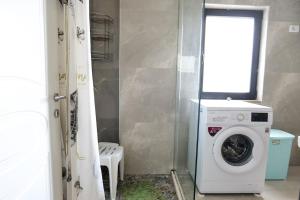 a washing machine in a bathroom with a window at Olive Qerret in Golem