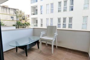 a chair and a glass table on a balcony at Olive Qerret in Golem