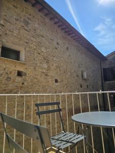 a balcony with a table and chairs and a brick wall at Casa Vacanze Todi in Todi