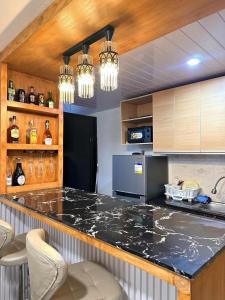 a kitchen with a large counter with chairs in it at Maria Staycation House in Davao City +19 photos