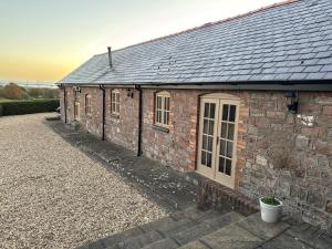 a brick building with windows and a roof at The Barn With A View in Portskewett