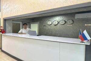 a man standing behind a counter with a laptop at Turkiye Hotel - Free Massage - Free Swimming Pool in Baku +41 photos