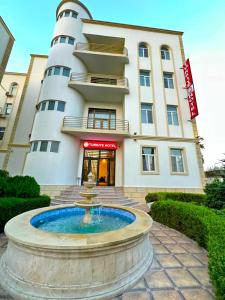 a building with a fountain in front of a building at Turkiye Hotel - Free Massage - Free Swimming Pool in Baku