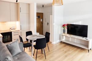a living room with a couch and a table and chairs at Park & Town Apartment in Drawsko Pomorskie