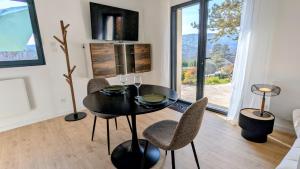 a dining room with a black table and chairs at Savigny Vineyard View & SPA in Savigny-lès-Beaune