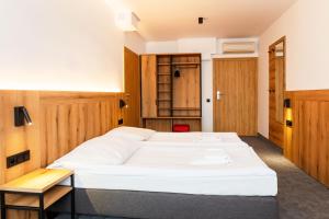 a large white bed in a room with wooden walls at Hotel Zawisza in Bydgoszcz