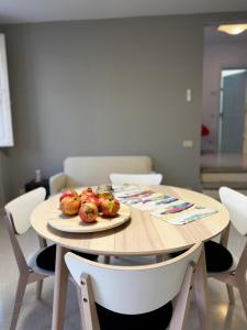 a wooden table with a plate of fruit on it at Appartamento Rosa Rosa' in Porto SantʼElpidio