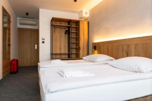 two beds in a room with white sheets at Hotel Zawisza in Bydgoszcz