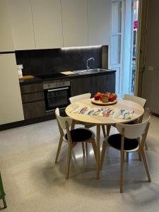 a kitchen with a table and chairs with a plate of fruit on it at Appartamento Rosa Rosa' in Porto SantʼElpidio