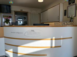 ein Empfangstresen in einer Kotekiewicz-Apotheke mit einem Logo in der Unterkunft Inklusions- und Panorama Hotel Kochsberg in Grebendorf