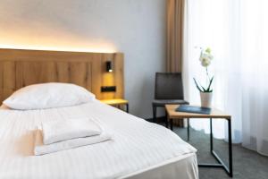 a bedroom with a bed with two towels on it at Hotel Zawisza in Bydgoszcz
