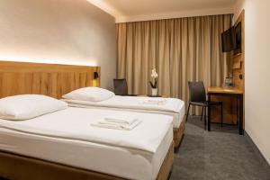 a hotel room with two beds and a desk at Hotel Zawisza in Bydgoszcz +35 photos