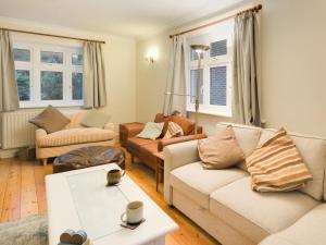 a living room with two couches and a table at 4 Bed in Swanage oc-dc046 in Studland