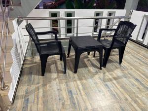 two black chairs and a table on a balcony at Diving Nest in Trincomalee +41 photos