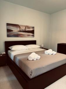 a bedroom with a bed with two towels on it at Appartamento Rosa Rosa' in Porto SantʼElpidio