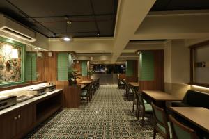 a restaurant with wooden tables and chairs and green walls at Sio Suites in Navi Mumbai