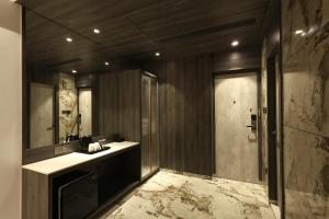 a bathroom with a sink and a mirror and a shower at Sio Suites in Navi Mumbai +54 photos