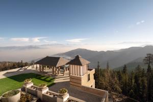 a house on a hill with a view of the mountains at The Greenberry Mountain Resort Narkanda in Nārkanda