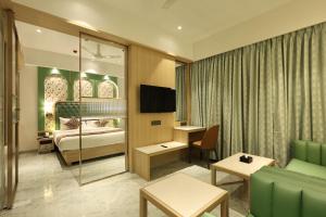 a hotel room with a bedroom and a bed at Sio Suites in Navi Mumbai