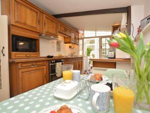 a kitchen with a table with food and orange juice at 1 Bed in Bridport oc-dc085 in Loders +14 photos