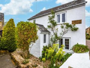 a white house with a garden in front of it at 1 Bed in Bridport oc-dc085 in Loders