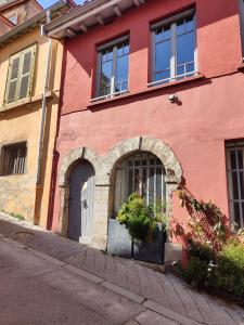 a red building with a door and a window at Bienvenue chez Sylvie in Lyon