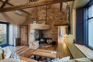 a living room with a stone fireplace and a table at Host & Stay - Kingbridge Forge in Lanercost