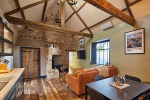 a kitchen and living room with a stone fireplace at Host & Stay - Kingbridge Forge in Lanercost +22 photos