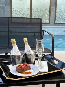 a table with a plate of food and two bottles of wine at Konke Calafate Hotel in El Calafate